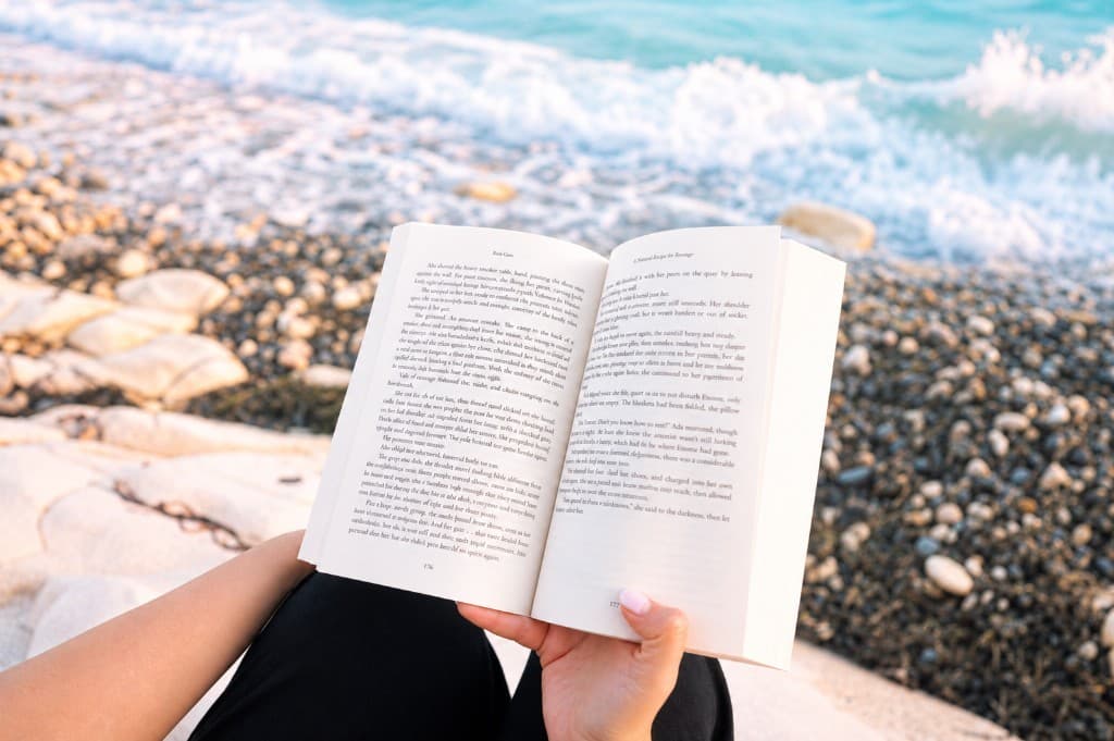 Reading an open book by the sea