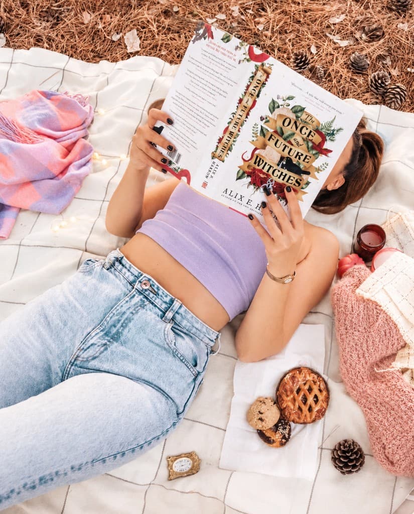 Reading under an open book on a picnic blanket